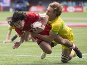 Australia's Jesse Parahi tries to stop Canada's Nathan Hirayama from scoring a try during the World Rugby Seven Series at B.C. Place in Vancouver, Saturday, March, 10, 2018. Canada has been given a challenging draw with Fiji, Samoa and Kenya in Pool B at the HSBC Canada Sevens this weekend at Vancouver's B.C. Place Stadium.