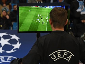 French referee Clement Turpin checks the VAR (Video Assistant Referee) equipment before the UEFA Champions League round of 16 second leg football match between Manchester City and Schalke 04 at the Etihad Stadium in Manchester, north west England, on March 12, 2019.