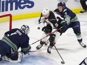 Seattle Thunderbirds' Zachary Ashton reaches around Vancouver Giants' Owen Hardy as his shot is stopped by T-birds goalie Roddy Ross in the second period.