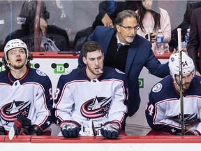Columbus Blue Jackets head coach John Tortorella, back, pats Adam McQuaid, right, on the back as he sits on the bench with Artemi Panarin, left, of Russia, and Pierre-Luc Dubois, centre, during the second period.