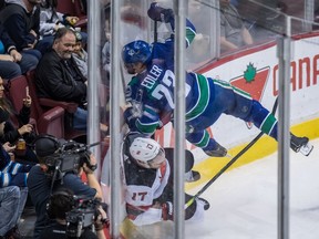 Alex Edler checks New Jersey Devils' Kenny Agostino last week.