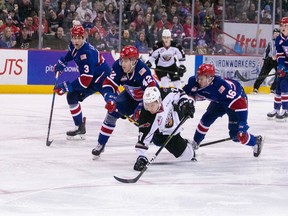 Yannik Valentiof the Vancouver Giants battle for a puck with several members of the Spokane Chiefs on Friday in Spokane.