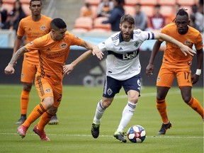 Houston Dynamo's Matias Vera (22) challenges Vancouver Whitecaps's Ion Erice (6) for the ball during the first half of an MLS soccer match Saturday, March 16, 2019, in Houston.
