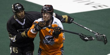 Vancouver Warriors' Keegan Bal tries to reach around ball-carrying Greg Downing of the New England Black Wolves in their regular season National Lacrosse League game at Rogers Arena on Saturday, March 16, 2019.