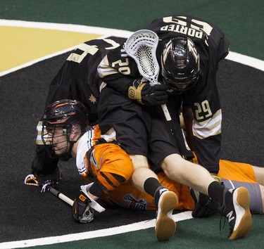 Two Vancouver Warriors players sprawl over New England Black Wolves' Quinn Powless after Powless scored in their regular season National Lacrosse League game at Rogers Arena on Saturday, March 16, 2019.