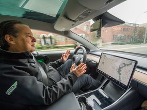 John Coupar of Novex Delivery Solutions "drives" a Tesla Model 3 with self-driving technology in Vancouver on Thursday.