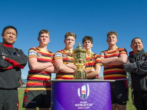 Members of the Charles Tupper Tigers, from the left, Auton Lum, Mark Matsalla, Jimmy Kinnear, Will Ainscough, Johnny Matsalla and Joseph Lee pose with the Webb Ellis Cup outside Hillcrest Centre in Vancouver on Wednesday.