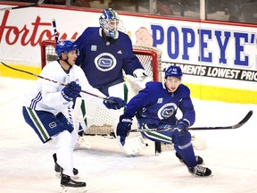 Vancouver Canucks' defenceman  Quinn Hughes, right, takes part in his first team practice at Rogers Arena on Wednesday. He's expected to make his NHL debut Thursday against the visiting Los Angeles Kings.