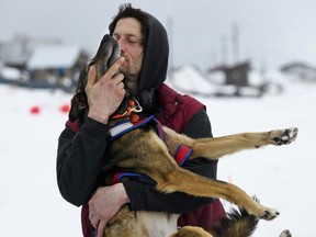 Nicolas Petit hugs one of his dogs before they leave Unalakleet, Alaska, during the Iditarod Trail Sled Dog Race on Sunday, March 10, 2019.