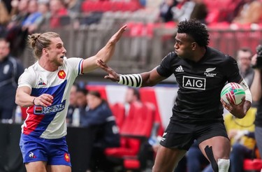New Zealand's Joe Ravouvou (4) runs the ball against France's Stephen Parez (5) during World Rugby Sevens Series action in Vancouver, B.C., on Saturday March 9, 2019.