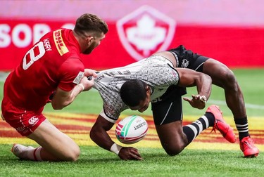Fiji's Aminiasi Tuimaba (11) scores a try while being tackled by Canada's Isaac Kaay (8) during World Rugby Sevens Series action in Vancouver, B.C., on Saturday, March 9, 2019.