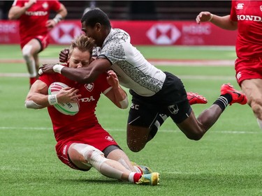 Fiji's Aminiasi Tuimaba (11) tackles Canada's Harry Jones (11) during World Rugby Sevens Series action in Vancouver, B.C., on Saturday, March 9, 2019.