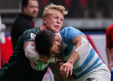 South Africa's JC Pretorius (left) runs the ball against Argentina's Lautaro Bazan Velez (7) during World Rugby Sevens Series action in Vancouver on Sunday, March 10, 2019.