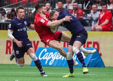Canada's Isaac Kaay (in red) and Scotland's Glenn Bryce collide during World Rugby Sevens Series action in Vancouver on Sunday, March 10, 2019.