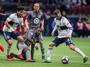 Vancouver Whitecaps' Jon Erice (6) plays the ball as teammate Fredy Montero (12) and Minnesota United's Ike Opara (3) look on during second half MLS soccer action in Vancouver on Saturday, March 2, 2019.