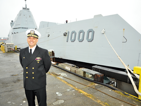 U.S. Navy Capt. Andrew Carlson, commander of the USS Zumwalt, stands in front of the stealth destroyer.