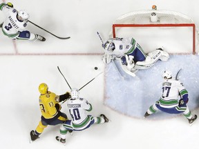 Jacob Markstrom blocks a shot by Nashville Predators center Nick Bonino during the first period.