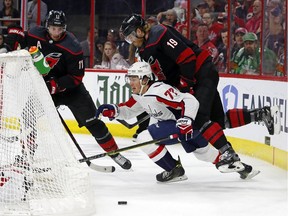 Washington Capitals' T.J. Oshie (77) battles behind the net with Carolina Hurricanes' Dougie Hamilton (19) and Jordan Staal (11) during the first period of Game 4 of their NHL first-round playoff series in Raleigh, N.C, on Thursday, April 18, 2019.