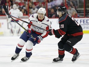 Hurricanes' Sebastian Aho, right, and Capitals' T.J. Oshie, left, chase the puck during the first period of Game 3 of an NHL first-round playoff series in Raleigh, N.C., Monday, April 15, 2019.