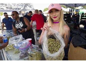FILE - In this Saturday, April 21, 2018 file photo a bud tender offers attendees the latest products of cannabis at the High Times 420 SoCal Cannabis Cup in San Bernardino, Calif. Businesses inside and outside the multibillion-dollar cannabis industry are using April 20, or "420," to roll out marketing and social media messaging aimed at connecting with marijuana enthusiasts.