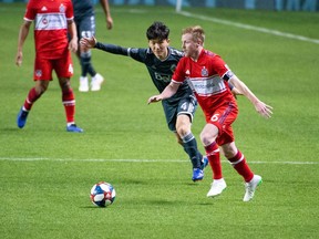 Dax McCarty of the Chicago Fire battles for ball and field position with Vancouver Whitecaps Inbeom Hwang during Friday's Major League Soccer match at SeatGeek Stadium in Chicago.