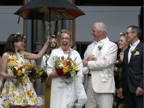 Federal Green party Leader Elizabeth May and her husband John Kidder greet the crowd as her daughter Cate holds an umbrella following their marriage during Earth Day at the Christ Church Cathedral in Victoria on Monday.