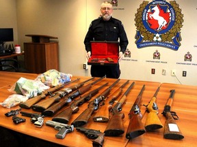 Chatham-Kent police firearms officer Const. Rob Tobin displays some of the firearms and ammunition turned in during a gun amnesty held during the month of April, in Chatham, Ont. on May 9, 2018.