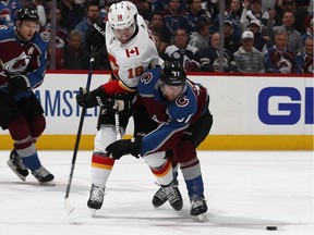 Colorado Avalanche left wing J.T. Compher, right, checks Calgary Flames left wing James Neal during the second period of Game 4 of an NHL hockey playoff series Wednesday, April 17, 2019, in Denver.