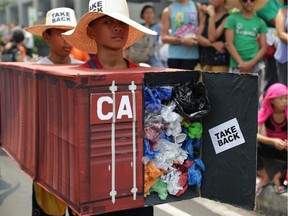Filipino environmental activists wear a mock container filled with garbage to symbolize the 103 containers of waste that were shipped from Canada to the Philippines in 2013. The president of the Philippines says if Canada doesn't take back its trash, he will 'declare war' and ship the containers back himself.