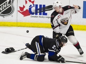 Bowen Byram of the Vancouver Giants  loses his glove as he checks Victoria Royals' Phillip Schultz to the ice during WHL playoff action at Langley Events Centre on April 6.