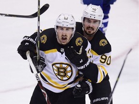 Boston Bruins left-winger Brad Marchand (left) celebrates his goal with Marcus Johansson during first-period NHL playoff action against the Toronto Maple Leafs in Toronto on Sunday, April 21, 2019.