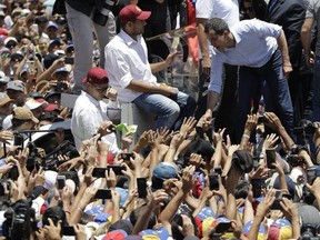 Opposition leader and self-proclaimed interim president Juan Guaido greets supporters during a rally to protest outages that left most of the country scrambling for days in the dark in Caracas, Venezuela, Saturday, April 6, 2019.