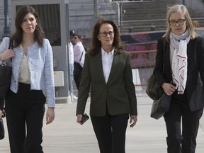 Kathy Russell, center, arrives at Federal court in the Brooklyn borough of New York, Friday, April 19, 2019. Russell is expected to plead guilty to charges implicating her in a sex-trafficking conspiracy case against an upstate New York self-help group.