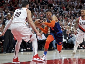 Oklahoma City Thunder guard Russell Westbrook, center, drives to the basket past Portland Trail Blazers guard Damian Lillard, right, and center Enes Kanter, left, during the first half of Game 5 of an NBA basketball first-round playoff series, Tuesday, April 23, 2019, in Portland, Ore.