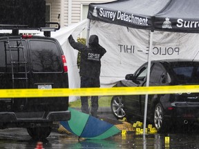 A crime-scene investigator probes a shooting at a townhome complex in the 13900-block of 72nd Avenue in Surrey on April 10.