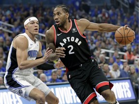 Toronto Raptors' Kawhi Leonard (2) drives to the basket against Orlando Magic's Aaron Gordon, left, during the first half in Game 4 of a first-round NBA basketball playoff series, Sunday, April 21, 2019, in Orlando, Fla.