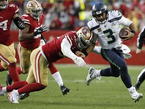 Seattle Seahawks quarterback Russell Wilson (3) runs against San Francisco 49ers defensive end DeForest Buckner during the second half of an NFL football game in Santa Clara, Calif., Sunday, Dec. 16, 2018.