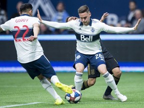 Vancouver Whitecaps defender Erik Godoy (22) and defender Jake Nerwinski (28) keeps Los Angeles FC forward Diego Rossi (9) from getting a shot on net during the first half of MLS soccer action in Vancouver, B.C. Wednesday, April, 17, 2019.