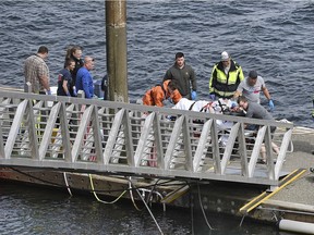 Emergency response crews transport an injured passenger to an ambulance at the George Inlet Lodge docks, Monday, May 13, 2019, in Ketchikan, Alaska. The passenger was from one of two float planes reported down in George Inlet early Monday afternoon and was dropped off by a U.S. Coast Guard 45-foot response boat. (Dustin Safranek/Ketchikan Daily News via AP) ORG XMIT: AKKET112