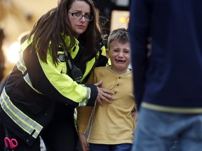 Officials guide students off a bus and into a recreation center where they were reunited with their parents after a shooting at a suburban Denver middle school Tuesday, May 7, 2019, in Highlands Ranch, Colo.