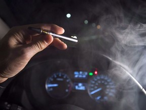 In this photo illustration, smoke from a cannabis oil vaporizer is seen as the driver is behind the wheel of a car in North Vancouver, B.C., on November 14, 2018. The federal government is boosting funding to help British Columbia police officers recognize drug-impaired drivers, months after it legalized recreational cannabis.