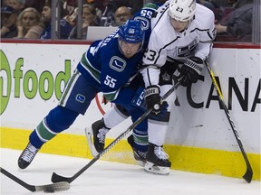 Vancouver Canucks' defenceman Alex Biega, left, rides Dustin Brown of the Los Angeles Kings into the boards during an NHL game at Rogers Arena in March.
