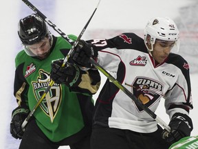 Justin Sourdif of the Vancouver Giants, right, battles Prince Albert Raiders' Cole Fonstad during the WHL championship series at the Langley Events Centre on May 10, 2019.