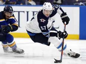 Winnipeg Jets defenceman Tyler Myers handles the puck with St. Louis Blues forward Robby Fabbri in pursuit during Game 6 of their NHL playoff first-round series on April 20, 2019 in St. Louis.