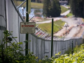 A no trespassing sign is seen posted outside double security fencing at the Kinder Morgan Burnaby Terminal tank farm, the terminus point of the Trans Mountain pipeline, in Burnaby, B.C., on Tuesday April 30, 2019.
