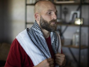Michael Behenna wears a scarf he brought home from Iraq at his farm near Guthrie, Okla., where he has been living since his parole from military prison. Trump pardoned Behenna Monday.
