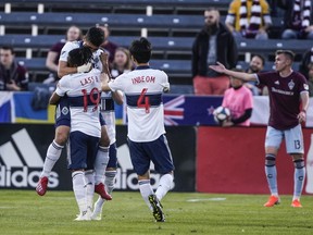 Vancouver Whitecaps forward Fredy Montero celebrates with teammates Lass Bangoura (19) and Hwang Inbeom (4) after scoring a goal against the Colorado Rapids during the first half of an MLS soccer match Friday, May 3, 2019, in Commerce City, Colo.