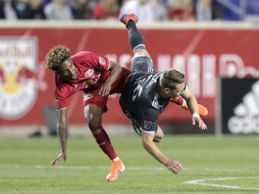 New York Red Bulls defender Kyle Duncan, left, and Vancouver Whitecaps' midfielder Brett Levis collide while competing for the ball during Wednesday's Major League Soccer action at Red Bull Arena in Harrison, N.J.