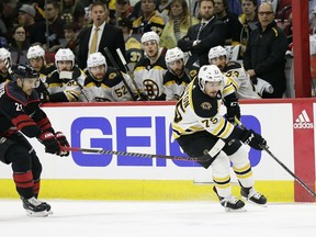Boston Bruins' Connor Clifton controls the puck while Carolina Hurricanes' Nino Niederreiter (21), of Switzerland, defends during the first period in Game 3 of the NHL hockey Stanley Cup Eastern Conference final series in Raleigh, N.C., Tuesday, May 14, 2019.