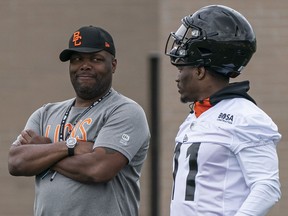 B.C. Lions head coach DeVone Claybrooks, left, keeps it real with defensive lineman Odell Willis at the CFL club's training camp in Kamloops.